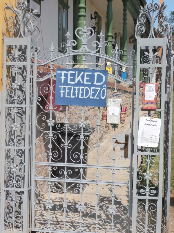 Stifolder fesztivál - a "Hagyományok udvara" porta kovácsoltvas kapuján plakát: falufelfedező játék